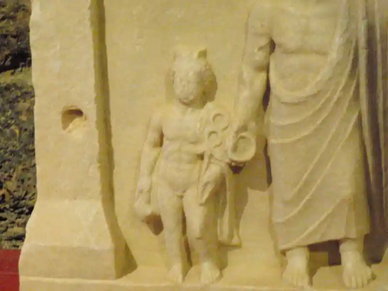 Child holding a winged cross with circles on top